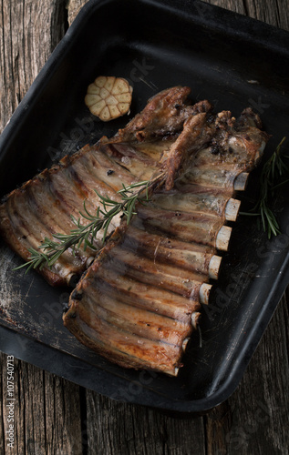 Grilled pork ribs with rosemary and garlic in a pan