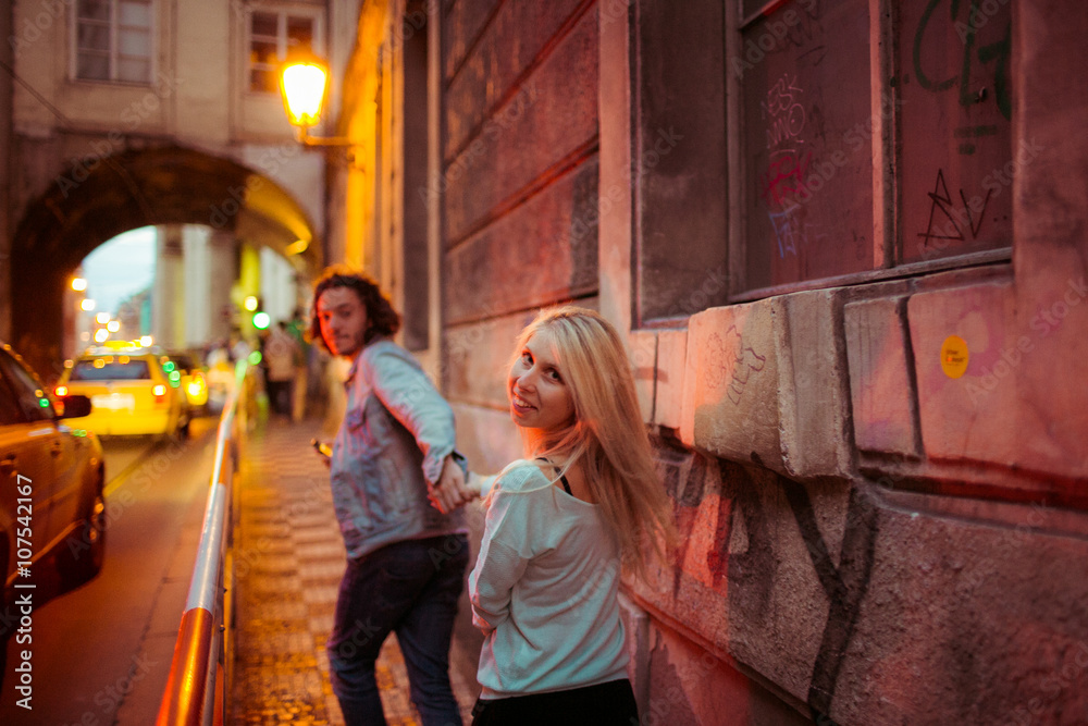 Romantic young couple walking & holding hands in Prague street