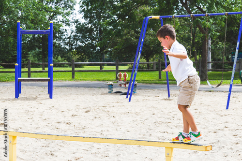 Child playing on the park play structure balance beam