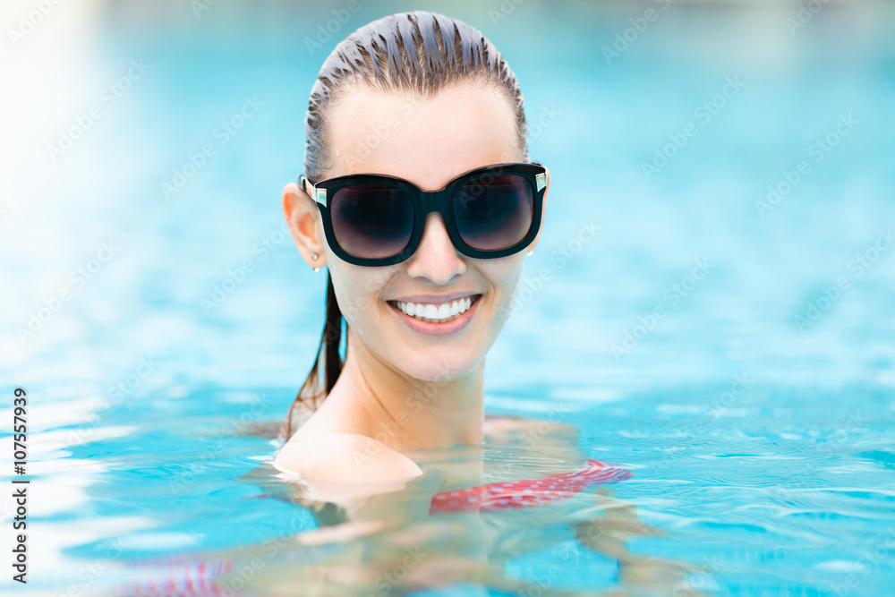 Attractive young woman relaxing in the pool. 