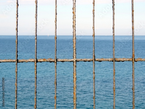 Rusty fence in front of the sea. © anastasiiam