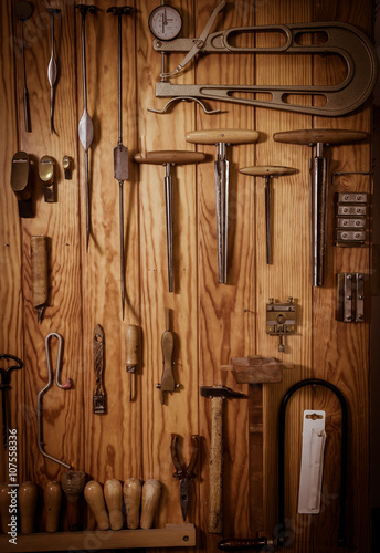 Many different old tools hanging on wall