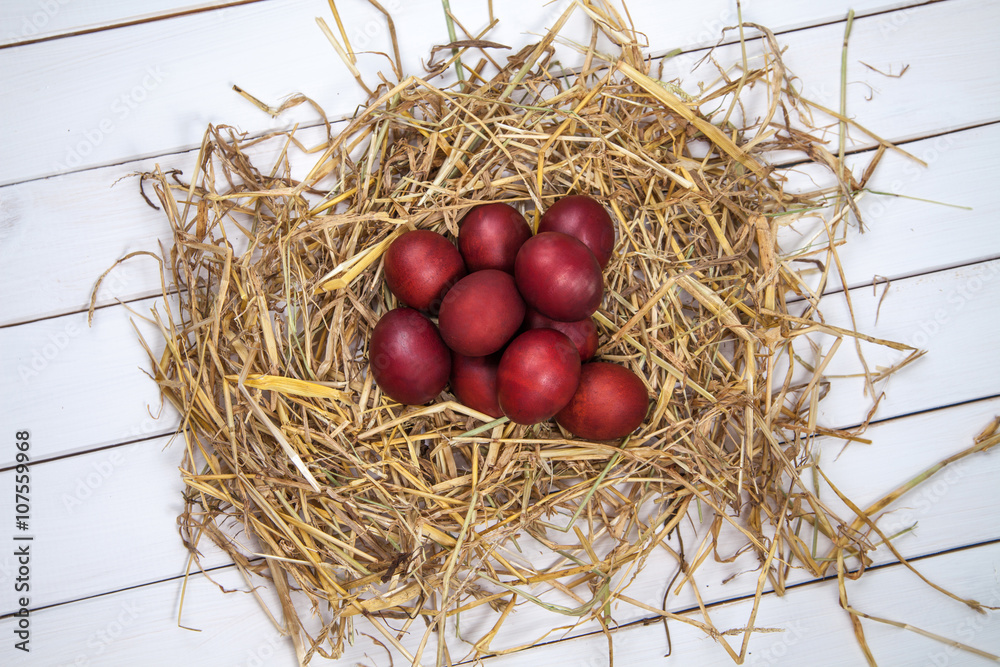 Easter eggs in a straw nest on rustic wooden background. Happy E Easter eggs in a straw nest on rustic wooden background. Happy E