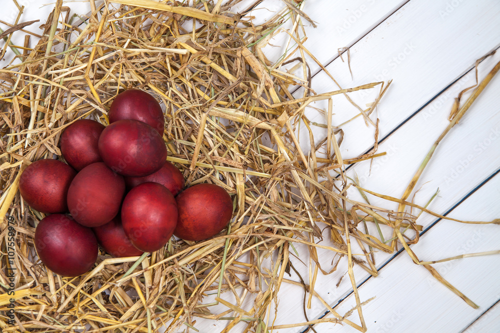 Easter eggs in a straw nest on rustic wooden background. Happy E Easter eggs in a straw nest on rustic wooden background. Happy E
