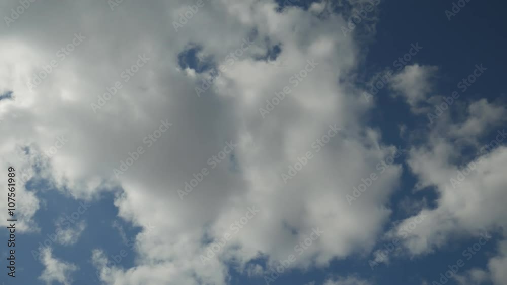 A blue sky with white clouds passing overhead A blue sky with white clouds passing overhead