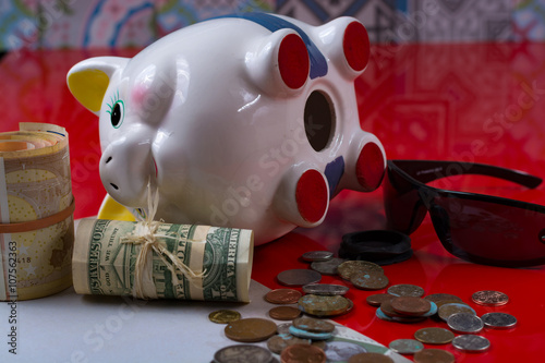 Opened piggy bank with black sunglasses and rolls cash photo