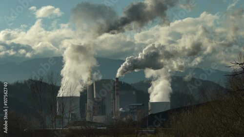 Working coal power plant with big smoke over chimneys.
 photo