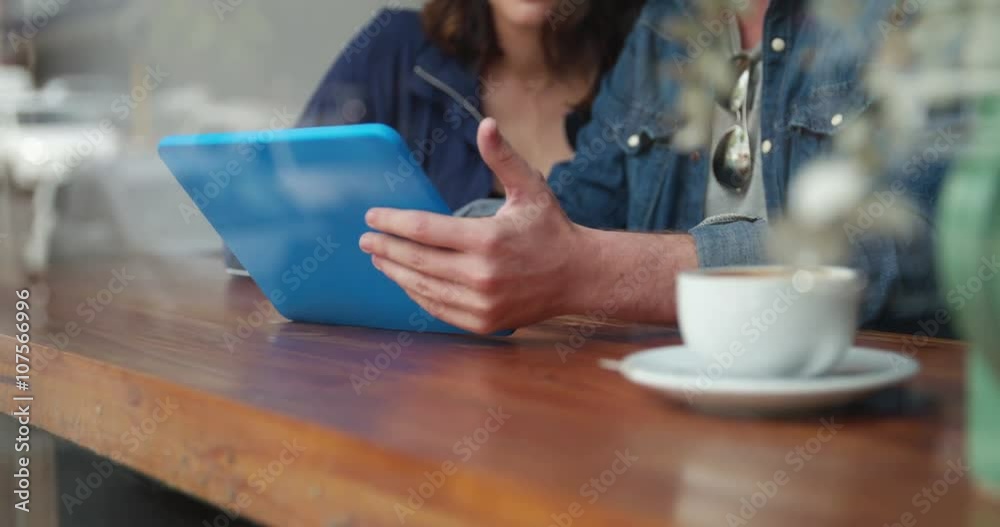 Woman and Man sitting in coffee shop with Tablet