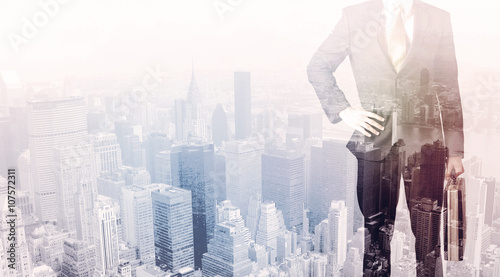 Business man standing on roof with city in the background