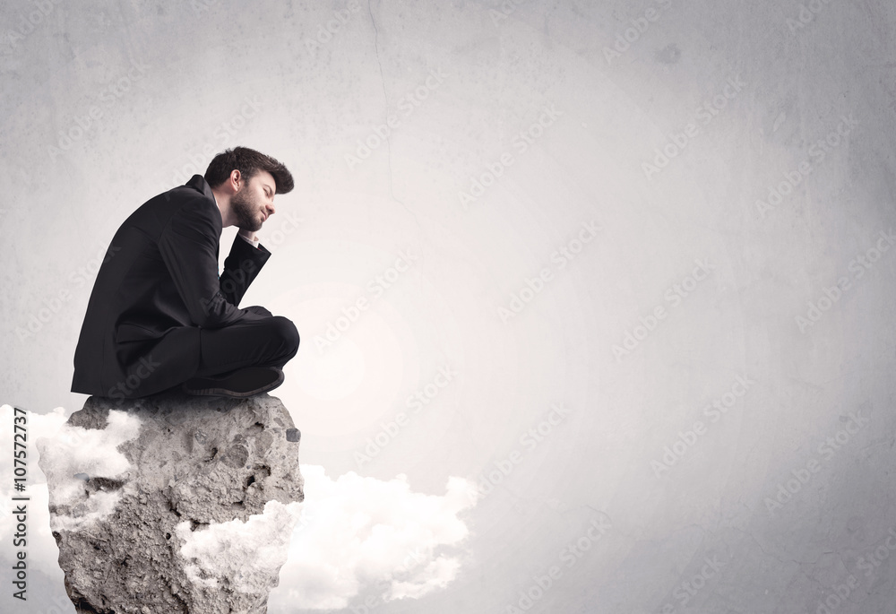 Office worker sitting on top of a rock Office worker sitting on top of a rock