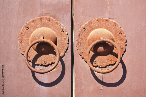 Obraz na plátně Ornate doorknockers on an old wooden door, Beijing, China