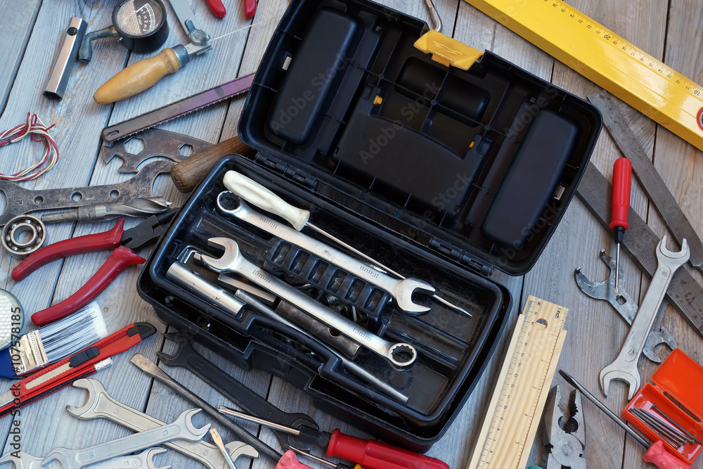 Fototapeta premium Tool box on wooden floor, view from above.