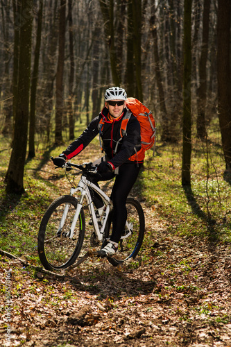 Fototapeta Naklejka Na Ścianę i Meble -  Mountain biker riding on bike in springforest landscape. 