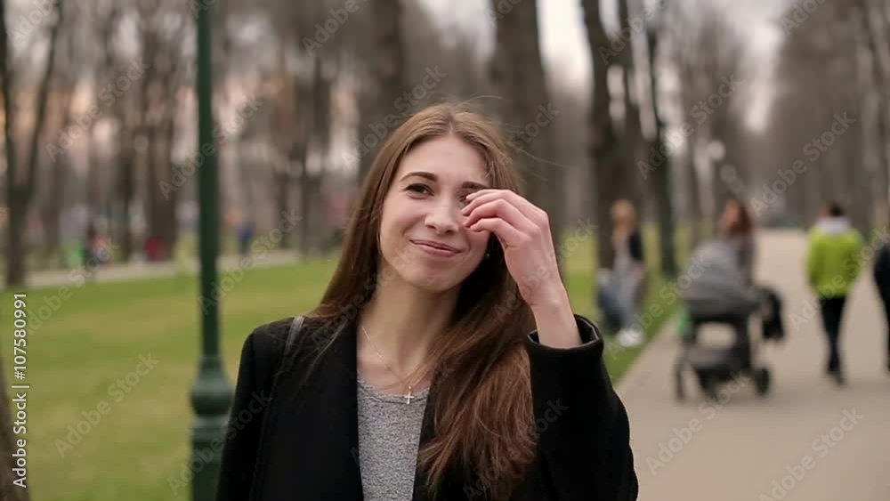 Young pretty girl smiles happily into camera, close up, slow motion Young pretty girl smiles happily into camera, close up, slow motion