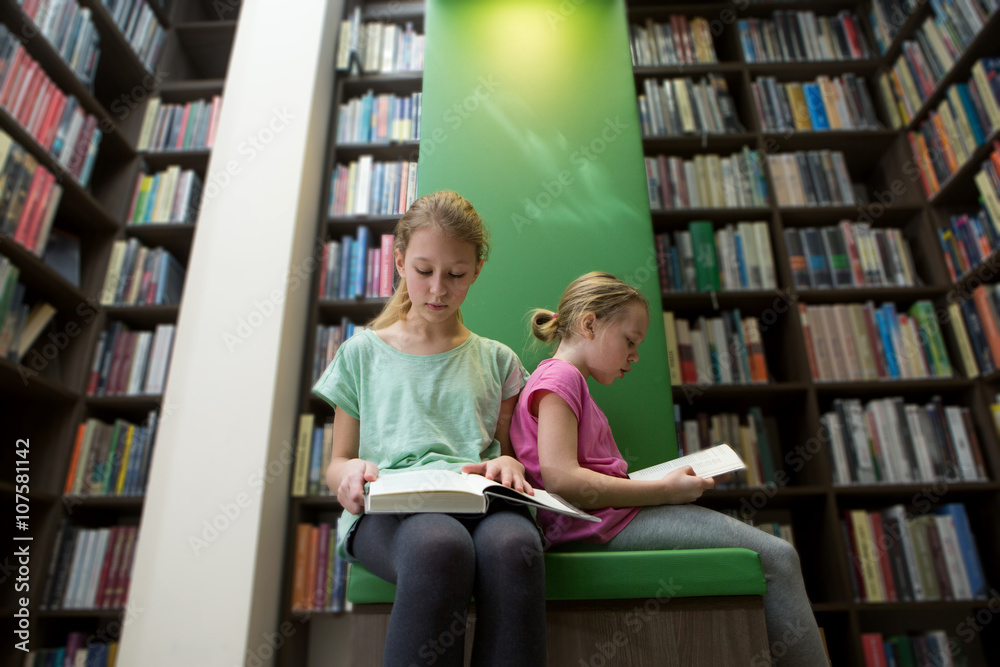Cute two girls reading book in library
Cute two girls reading book in library