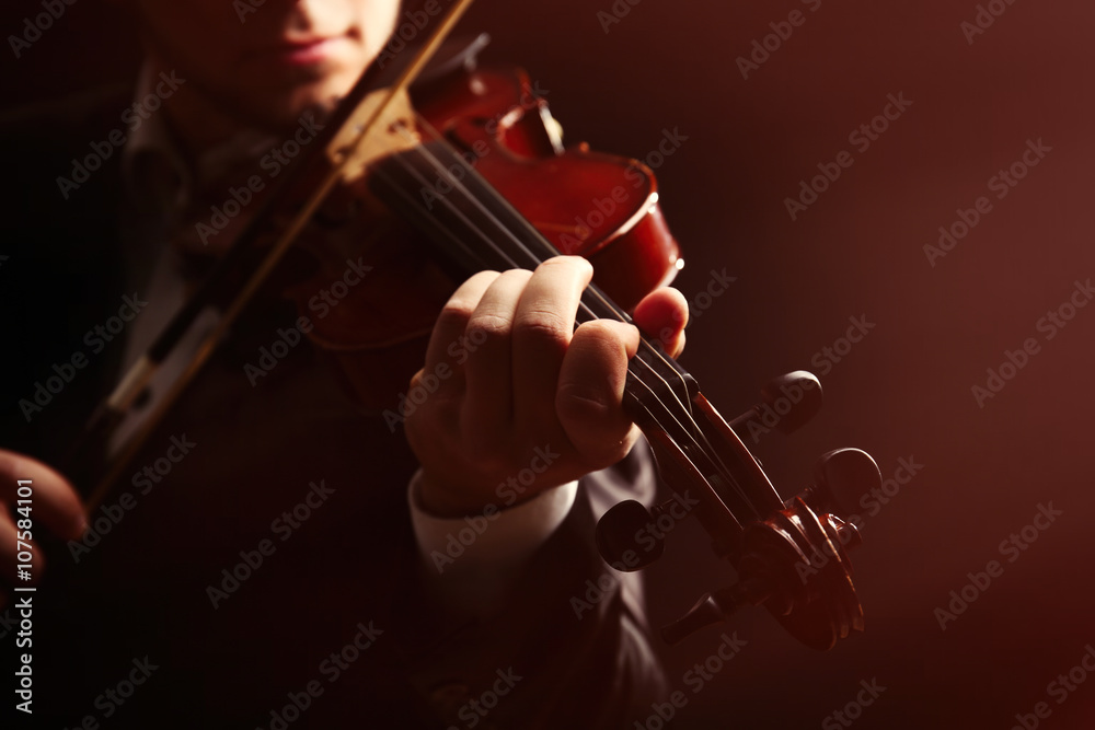 Musician play violin on dark background, close up Musician play violin on dark background, close up