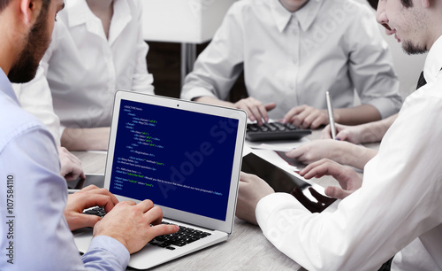 Man using laptop, writing p...