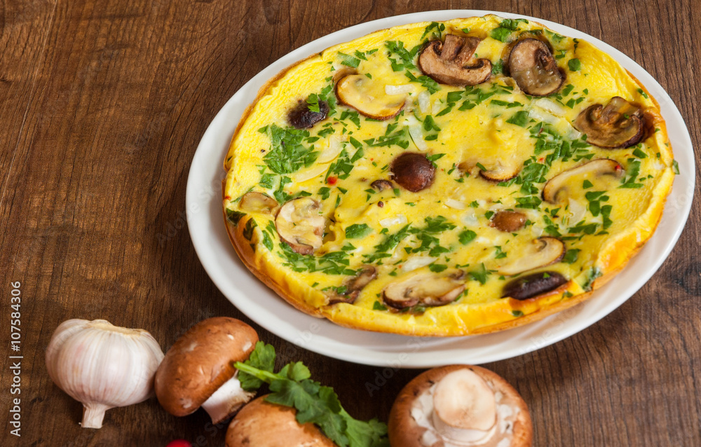 omelet with mushrooms in a plate on wooden table omelet with mushrooms in a plate on wooden table