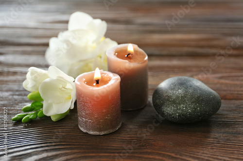 Spa composition with candle  pebbles and aroma oil on wooden background