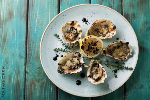 Baked oysters with sauce and cheese on a plate