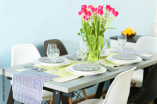 Table served with dishes and a bouquet of tulips