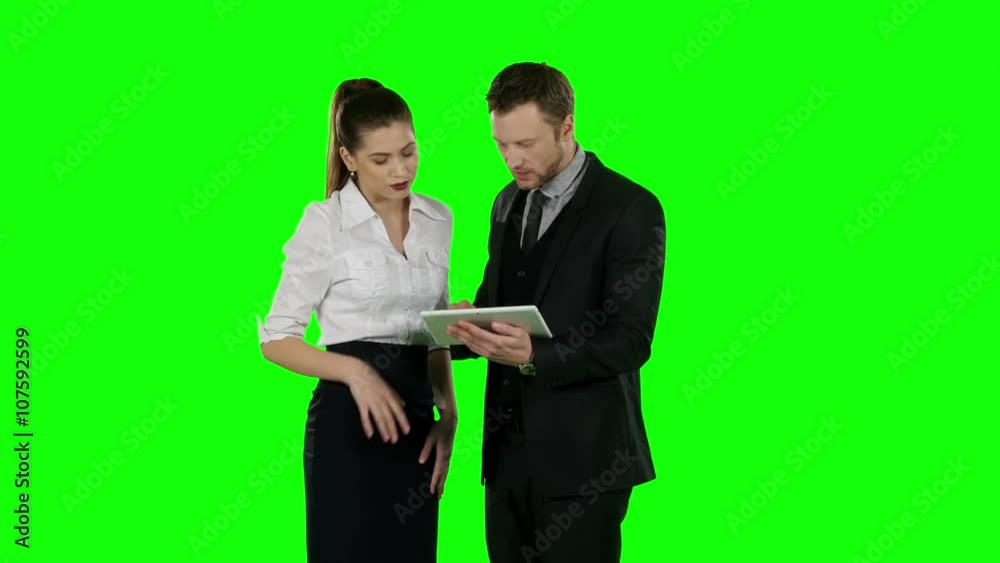 Two office worker look at a laptop together. Green screen Two office worker look at a laptop together. Green screen