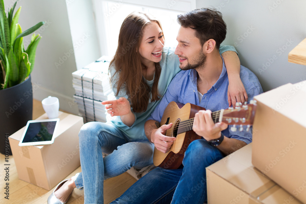 Couple with unpacked boxes in new home Couple with unpacked boxes in new home