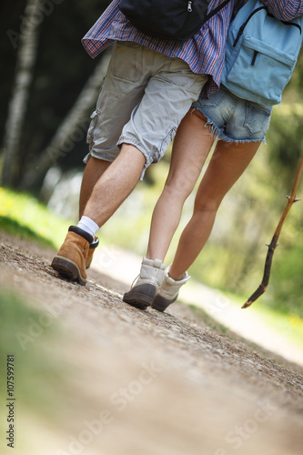 Young couple hiking in nature on beautiful summer day.