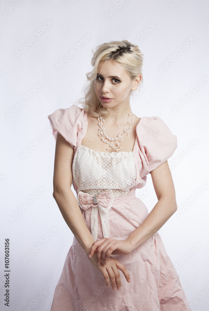 Girl in pink clothes on a gray background folded her hands on her hips Girl in pink clothes on a gray background folded her hands on her hips