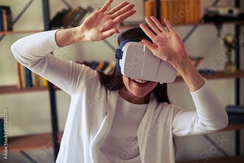 Woman hiding from something using hi-tech virtual reality headse photo