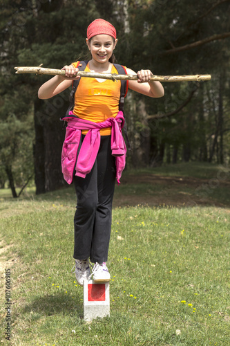 Young girl balances on a boundary marker
