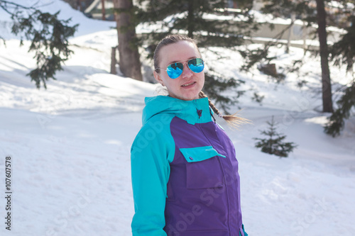 young girl in sunglasses on a background of snow