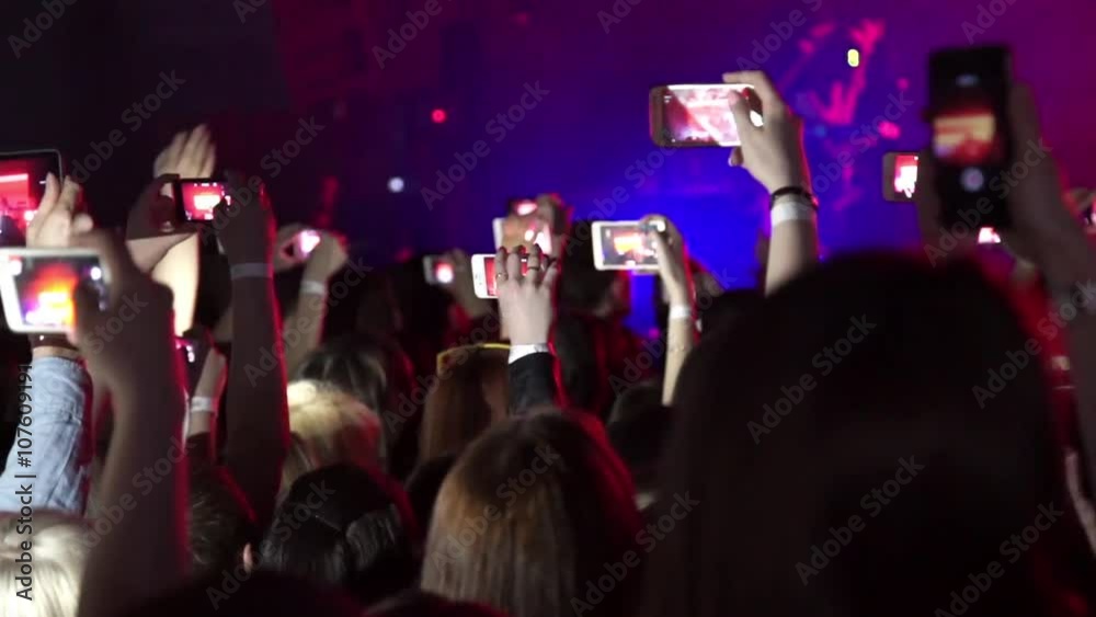 Party at a rock concert and hold cameras with digital displays Party at a rock concert and hold cameras with digital displays