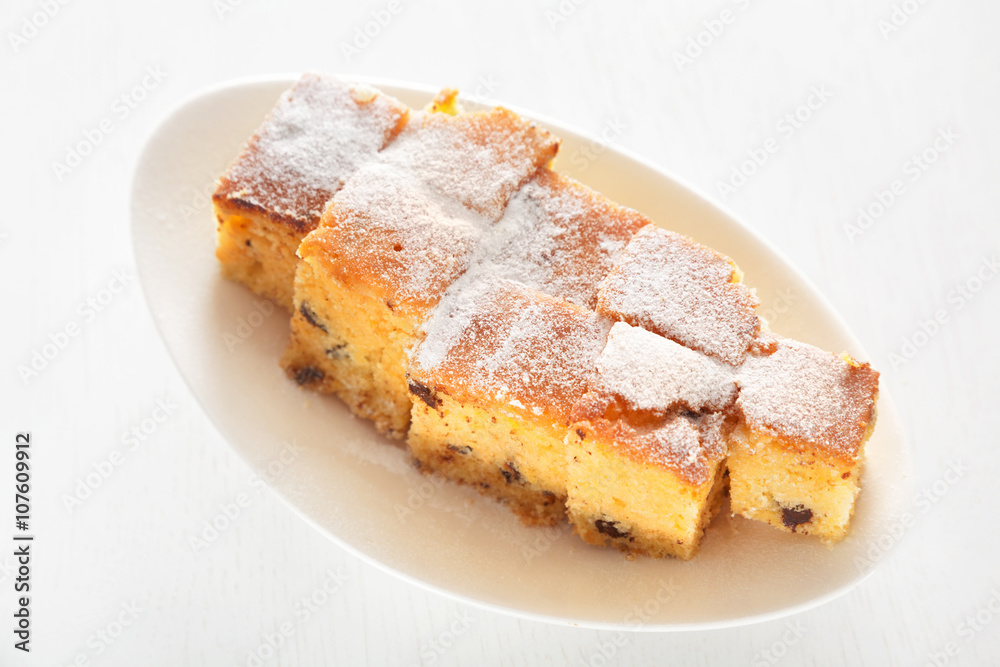 Homemade lemon cake with chocolate chips shot over white background from above. Full length view Homemade lemon cake with chocolate chips shot over white background from above. Full length view