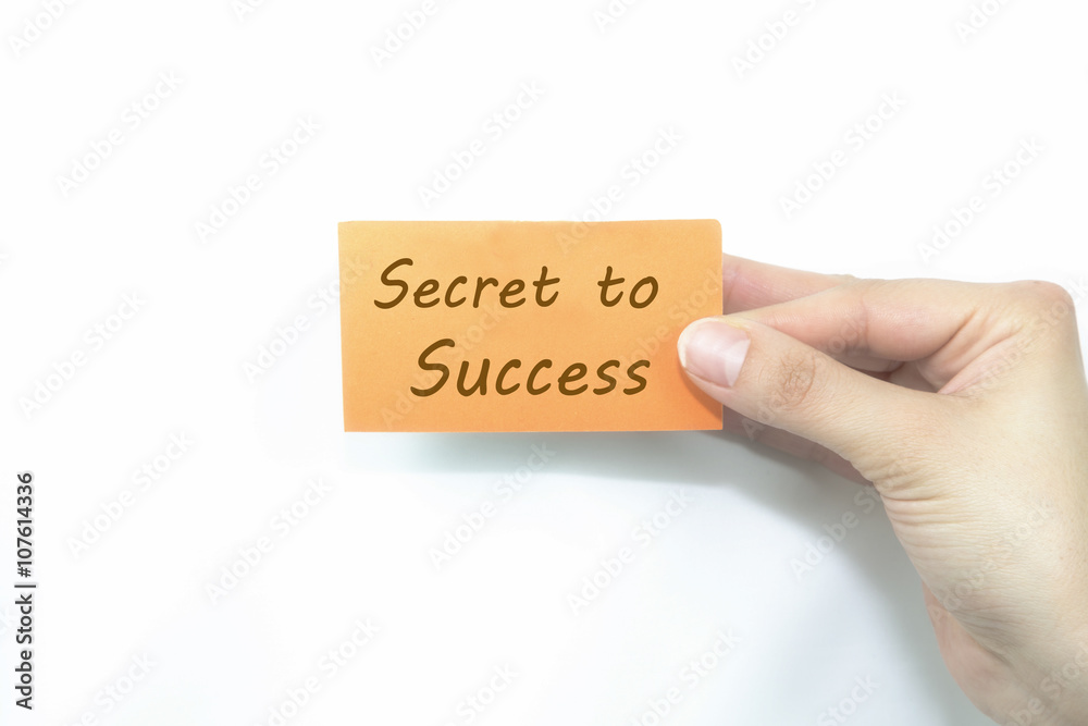 hand holding orange card written secret to success over isolated hand holding orange card written secret to success over isolated