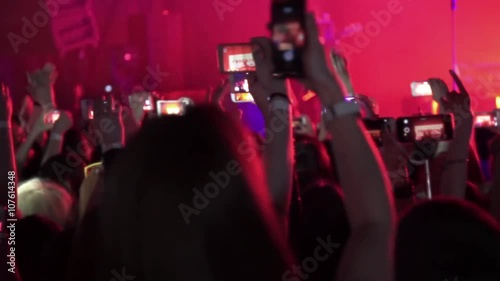 People taking photos or recording video with their smart phones at music concert