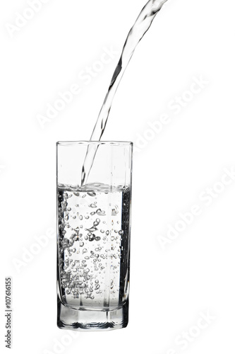 Water pouring into glass, air bubbles in the water, isolated on