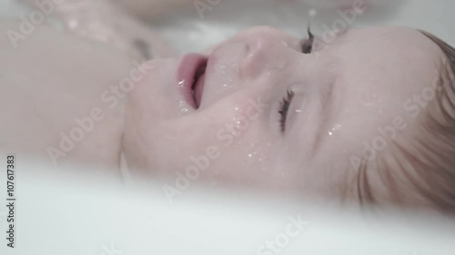 the child bathes in a bathroom  