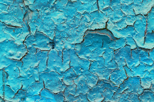 Close-up of a turquoise paint peeled off of a wall texture background.