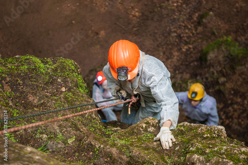 Speleologists descends into a cave. photo