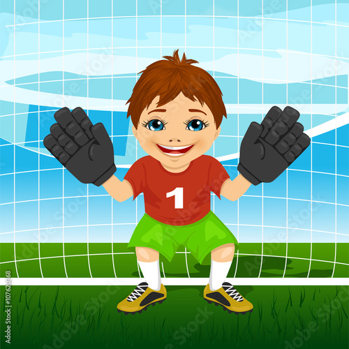 Young goalkeeper boy wearing red and green sportswear in a ready position 