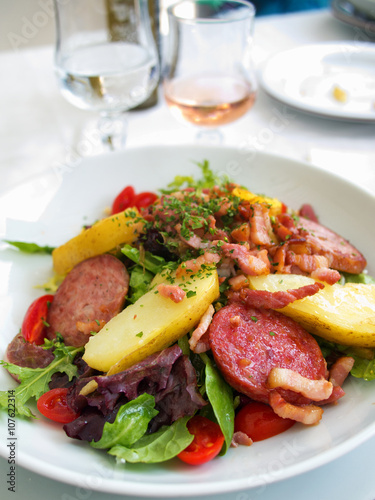 Gourmet salad with vegetables and fried ham served in a small beach restaurant in Cannes, France