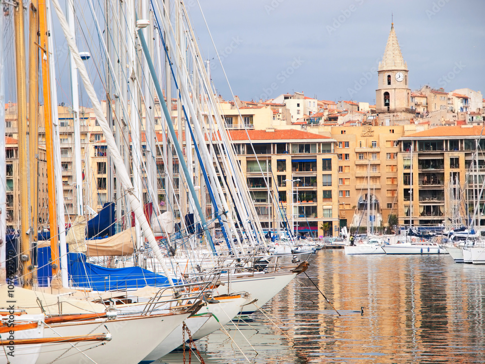 Yachts in the port of Marseille, France on a sunny day. Clock tower and buildings on background. Horizontal shot