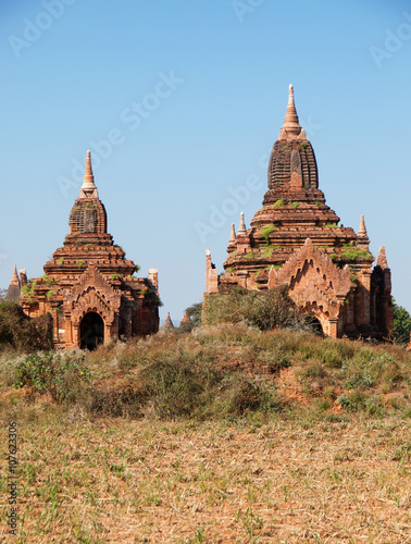 Two ancient pagodas in Bagan, Myanmar, blue sky in background.Vertical shot
