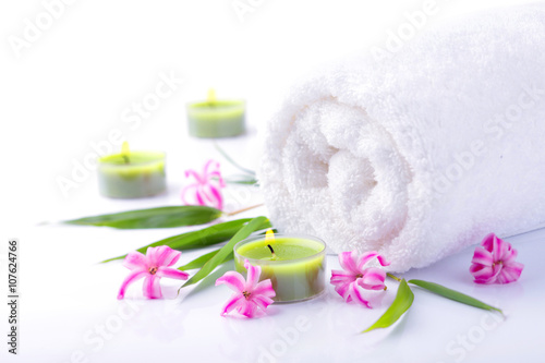 Spa Still Life - Wei  es Handtuch mit Bl  ten und Kerzen vor wei  em Hintergrund