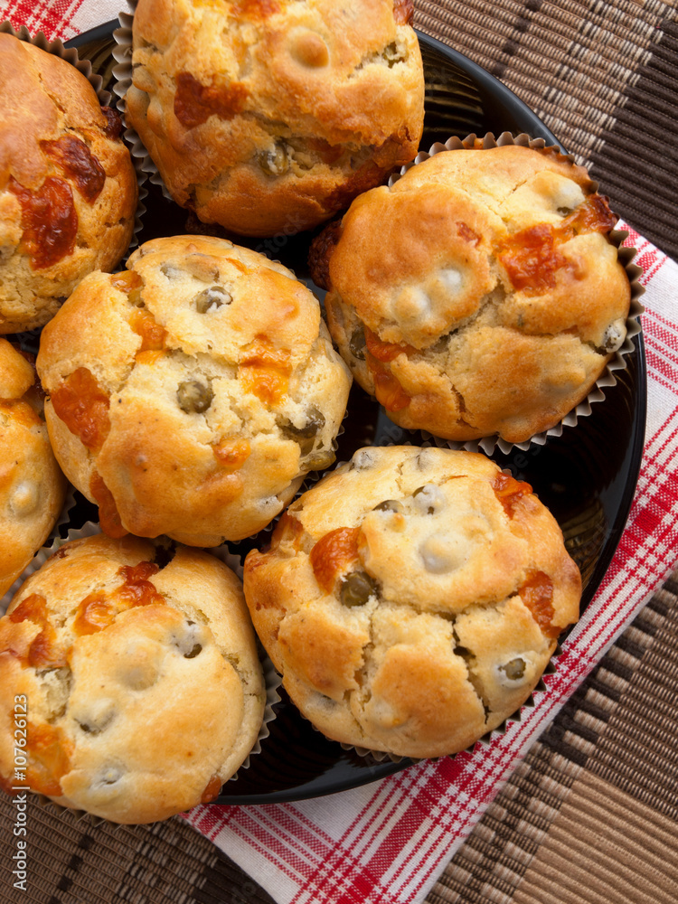 Savory muffins with ham, cheese dried tomatoes, shot from above