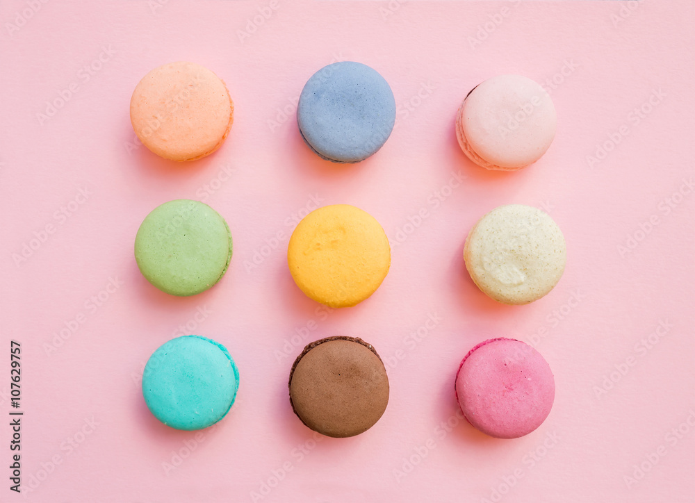 Sweet colorful French macaroon biscuits on pastel pink background Sweet colorful French macaroon biscuits on pastel pink background