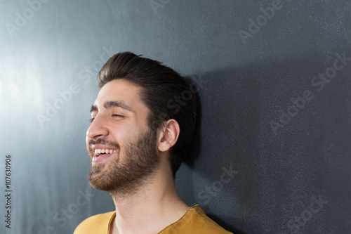 Fototapeta Naklejka Na Ścianę i Meble -  sexy man with beard smiling big against wall