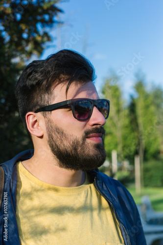 Portrait of a young handsome man,sitting outdoors, with toupee a