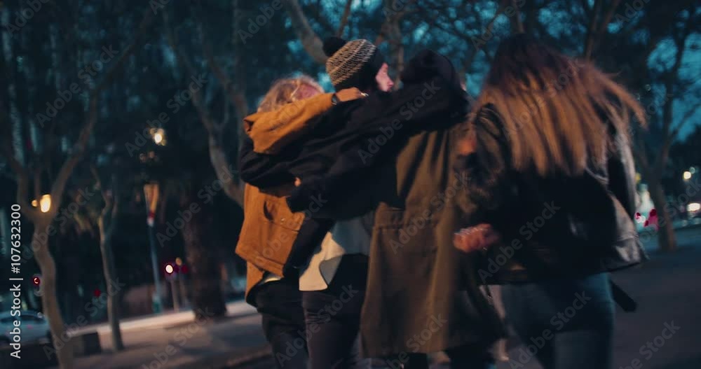 Young happy couples embracing while taking a night walk outside